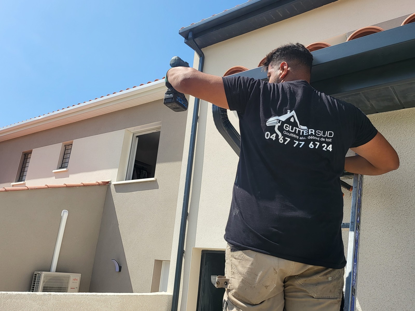 Ouvrier en intervention pour la pose de gouttières couleur gris anthracite